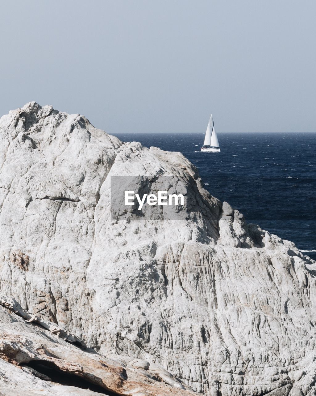 Sailboat in sea against clear sky