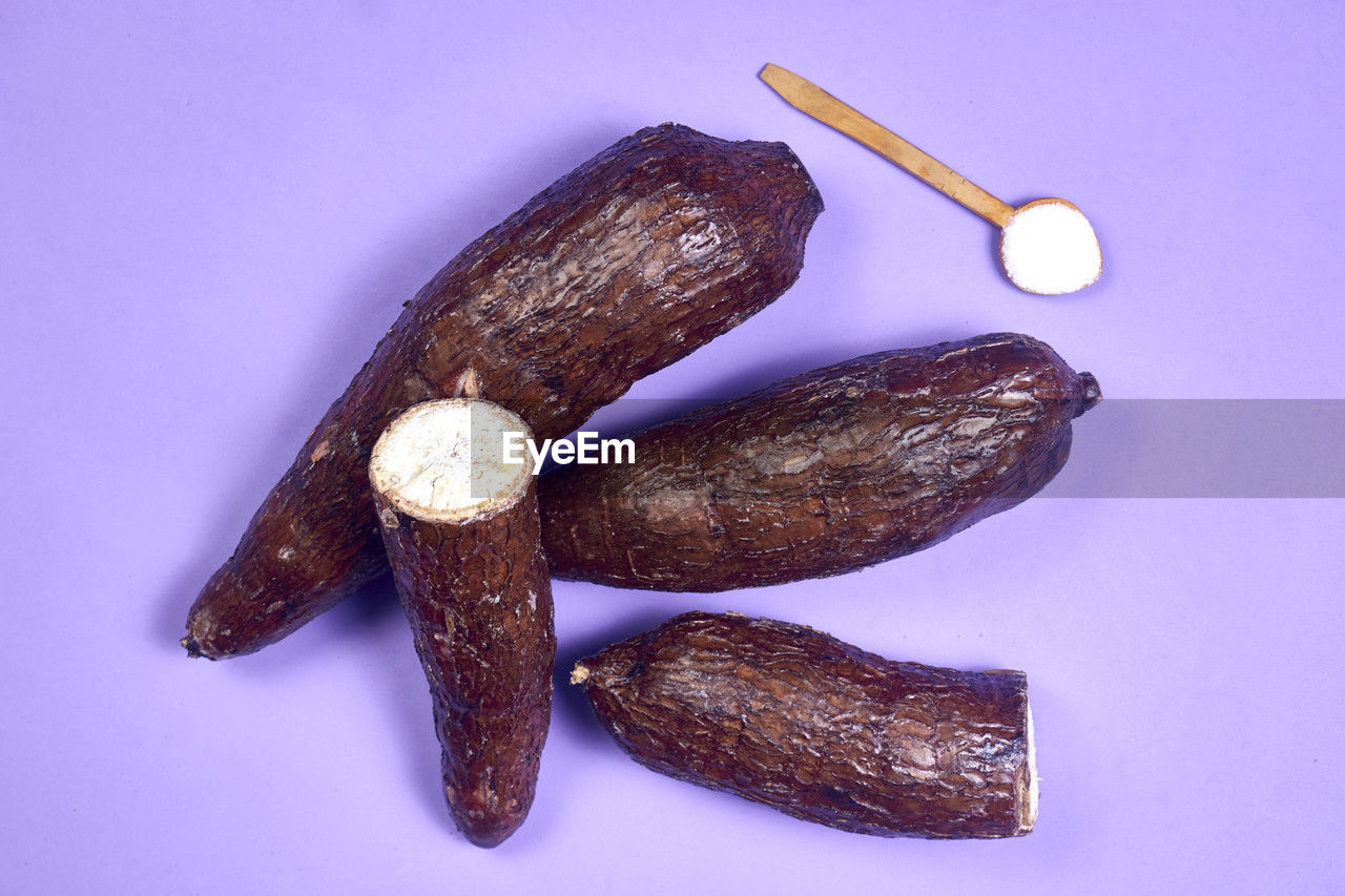 Fresh organic cassava root, manioc esculenta, yuca on purple background