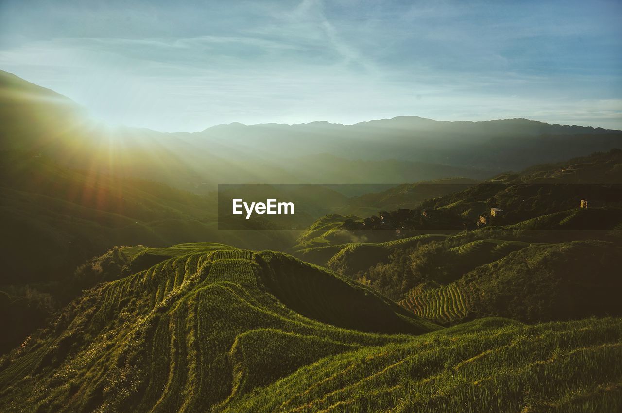 Scenic view of rice terraces against cloudy sky during sunrise
