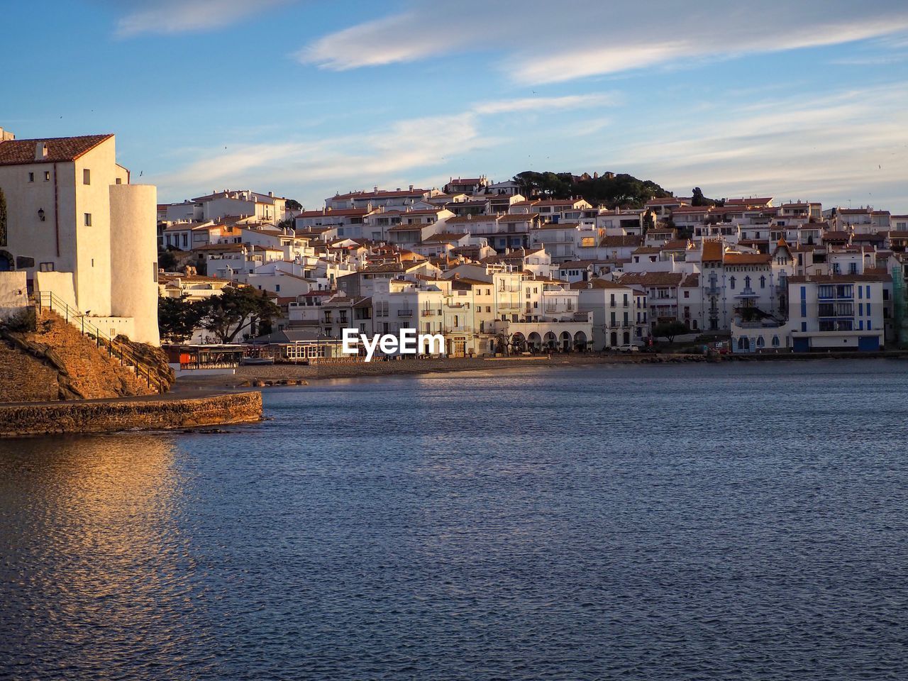 Buildings by sea against sky in town