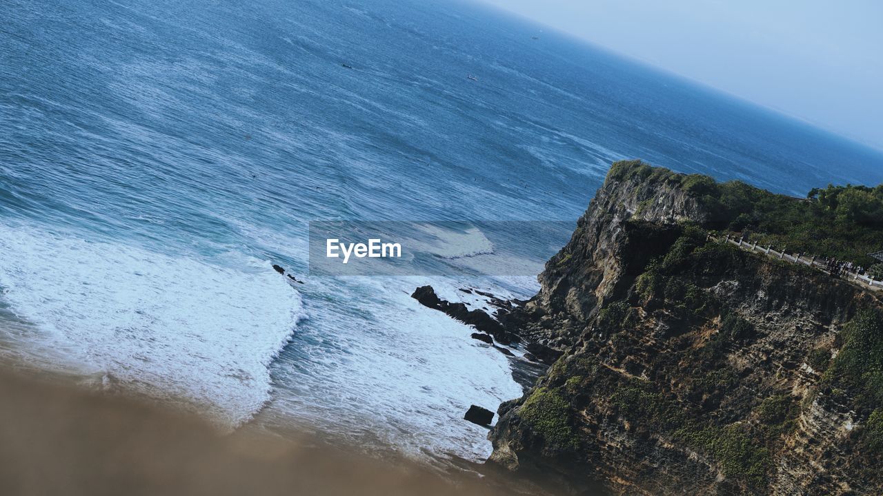 HIGH ANGLE VIEW OF ROCKS ON SHORE AT SEA