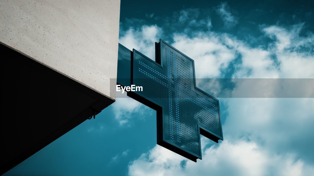 Low angle view of sign on building against sky