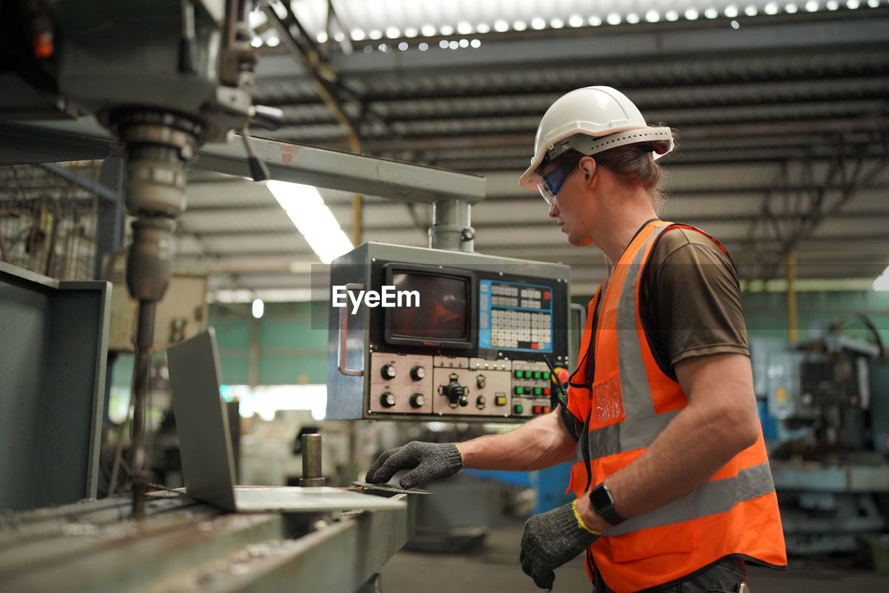 Rear view of man standing in factory