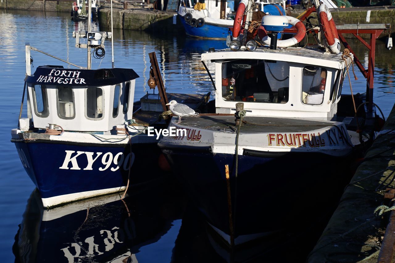 BOATS MOORED IN SEA