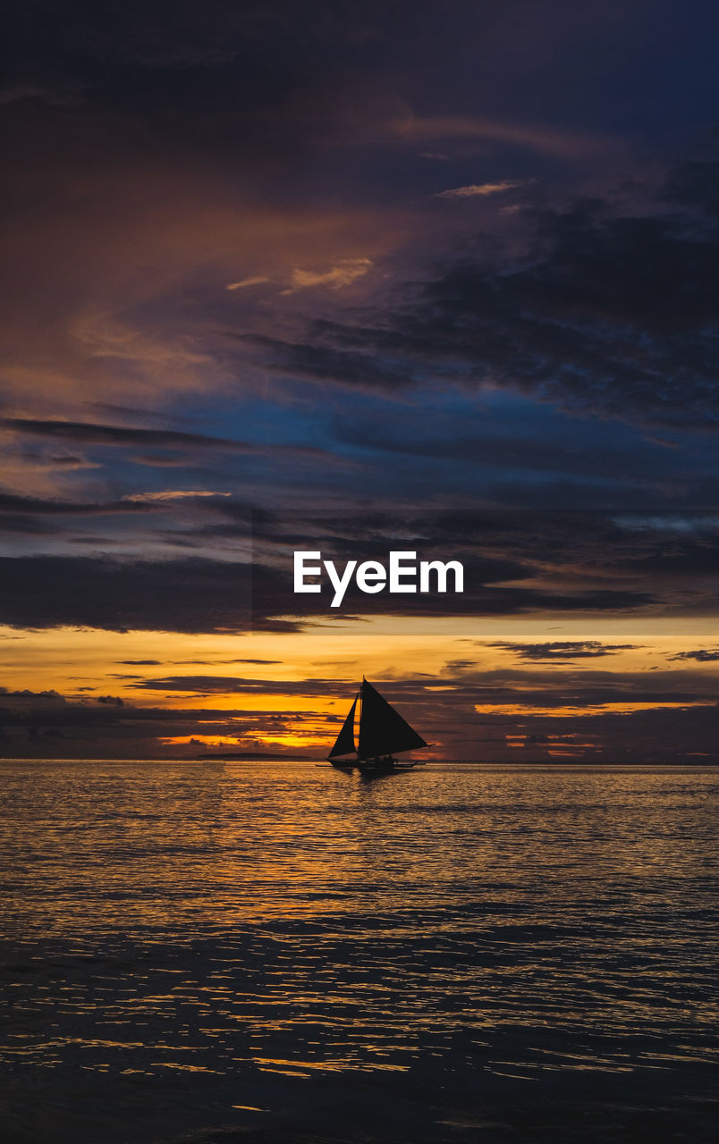 Silhouette sailboat on sea against sky during sunset