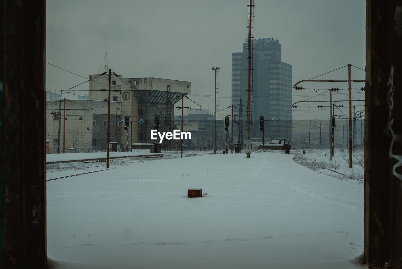 SNOW COVERED BUILDINGS BY CITY AGAINST SKY