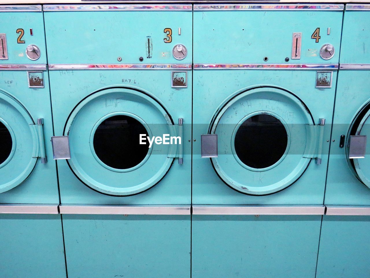 Full frame shot of turquoise washing machines in laundromat