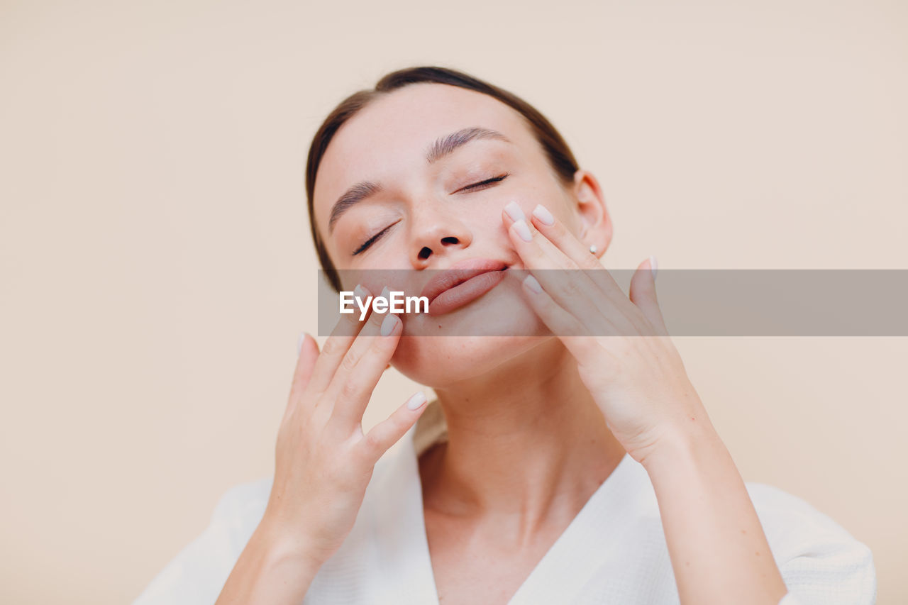 Woman with closed eyes against colored background