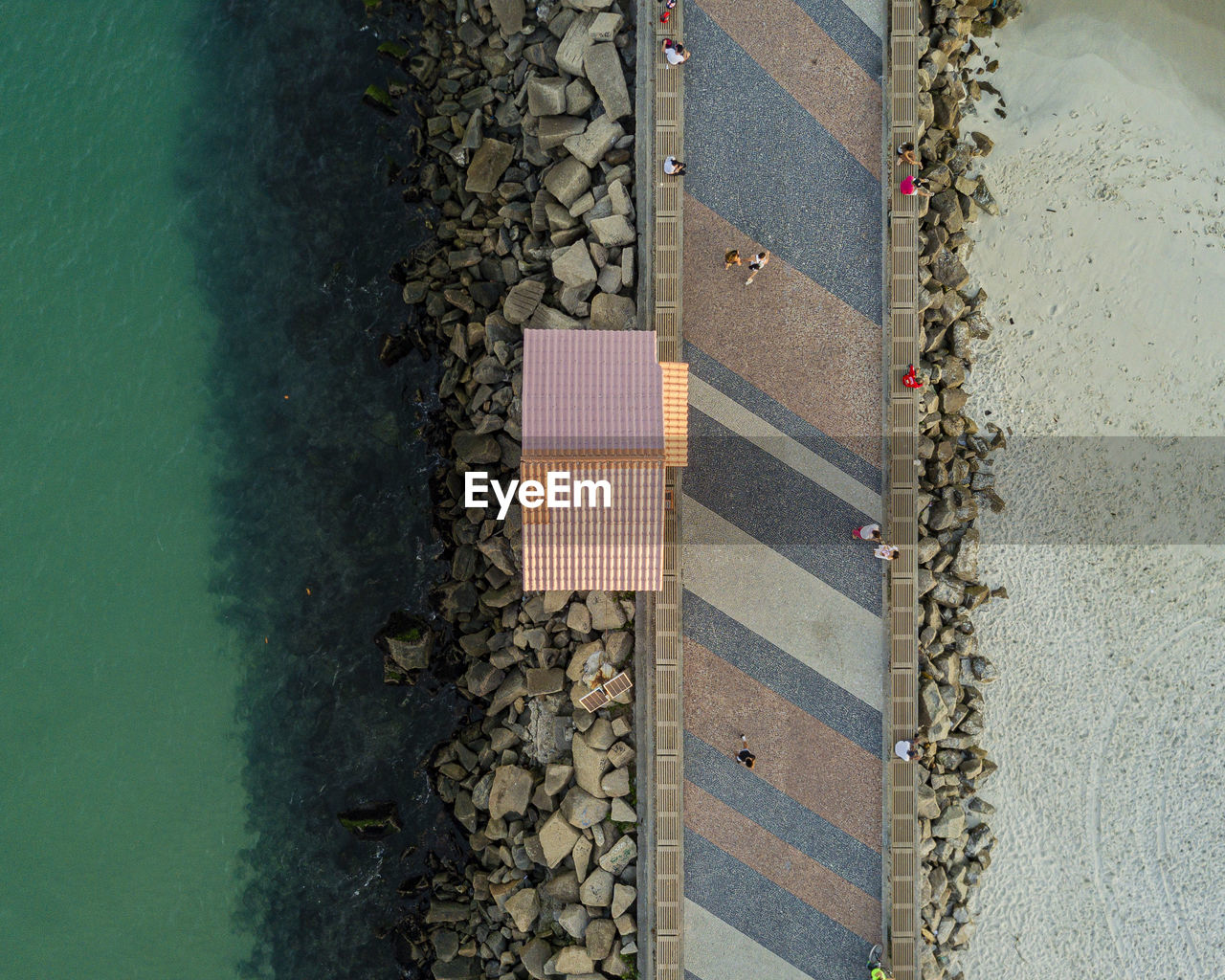 Aerial view of people waking on pier by sea