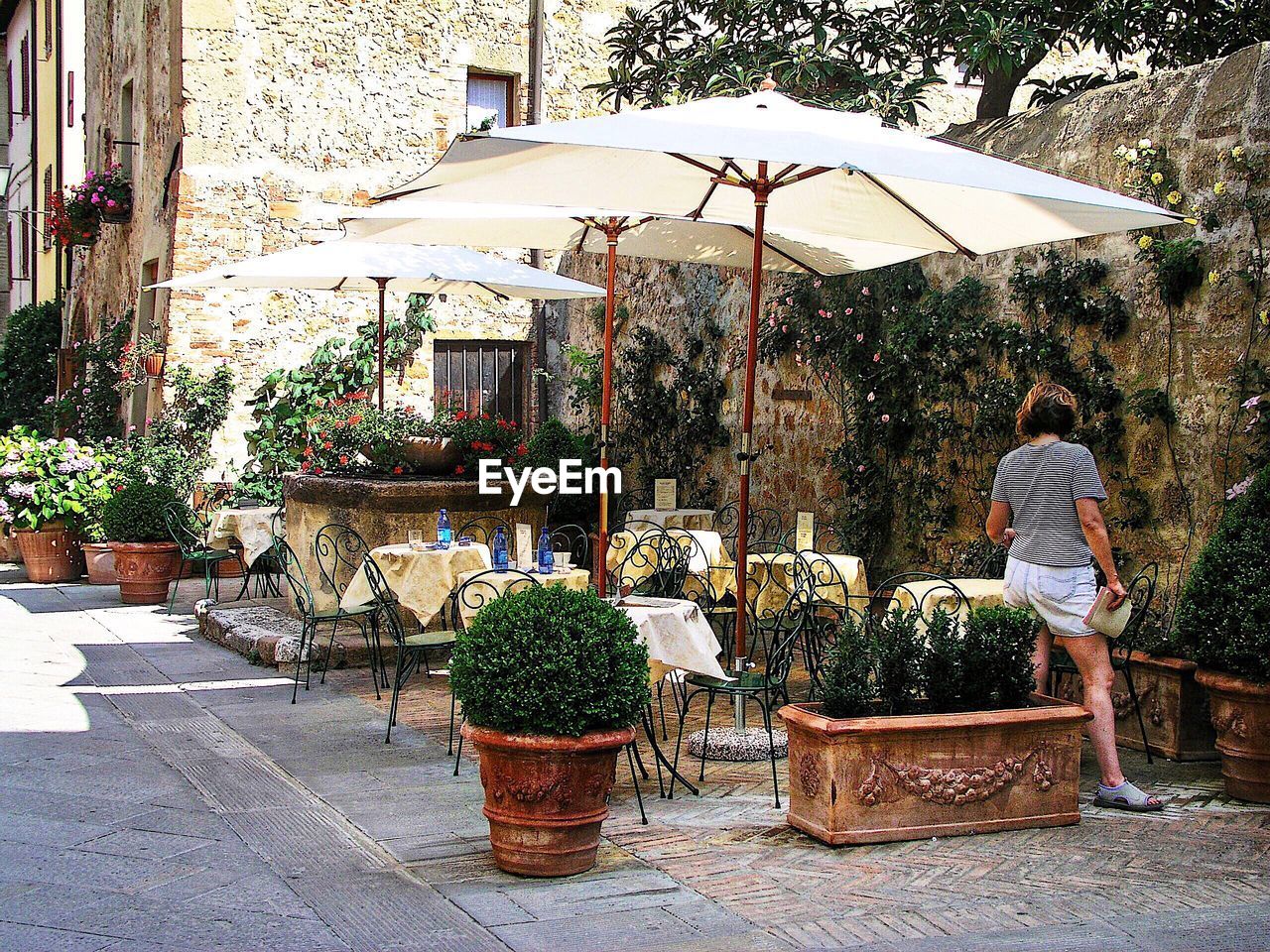 Rear view of woman standing at sidewalk cafe