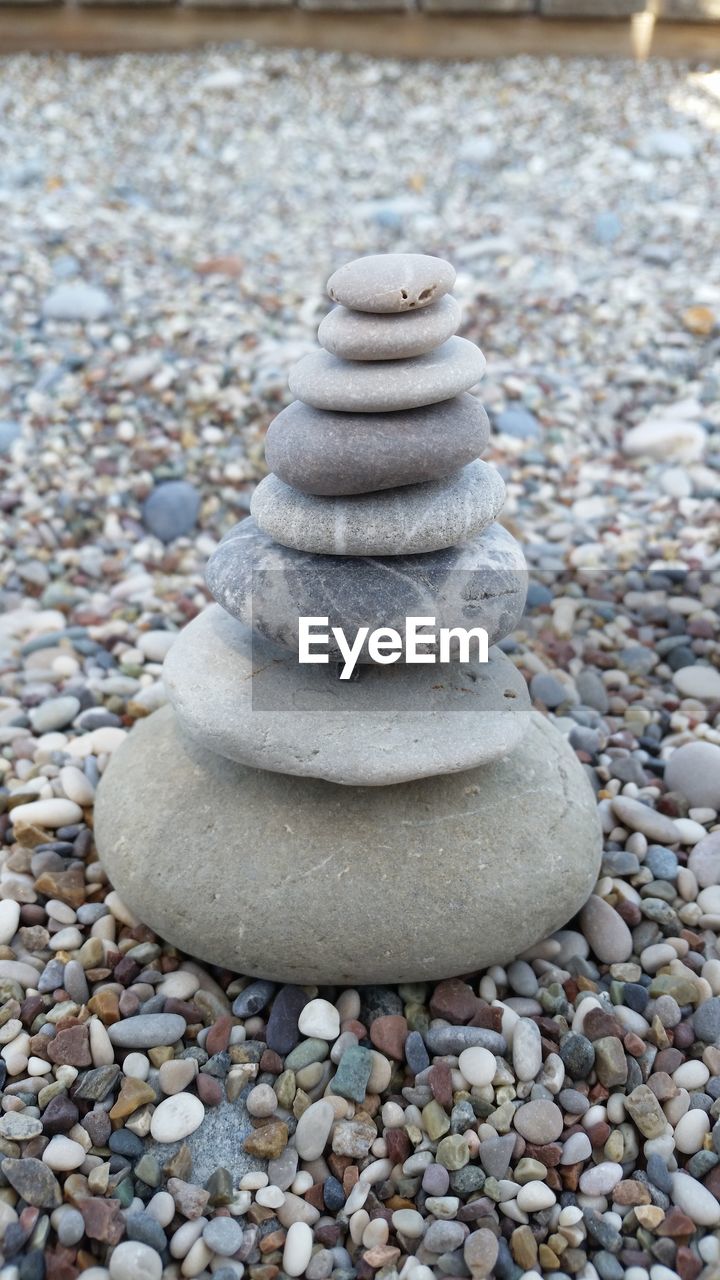 CLOSE-UP OF PEBBLES ON SHORE