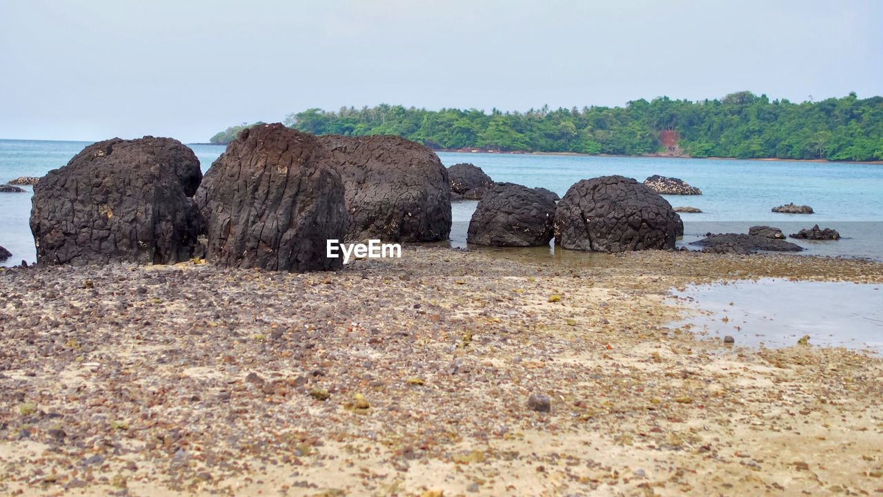 ROCKS ON SHORE AGAINST SKY