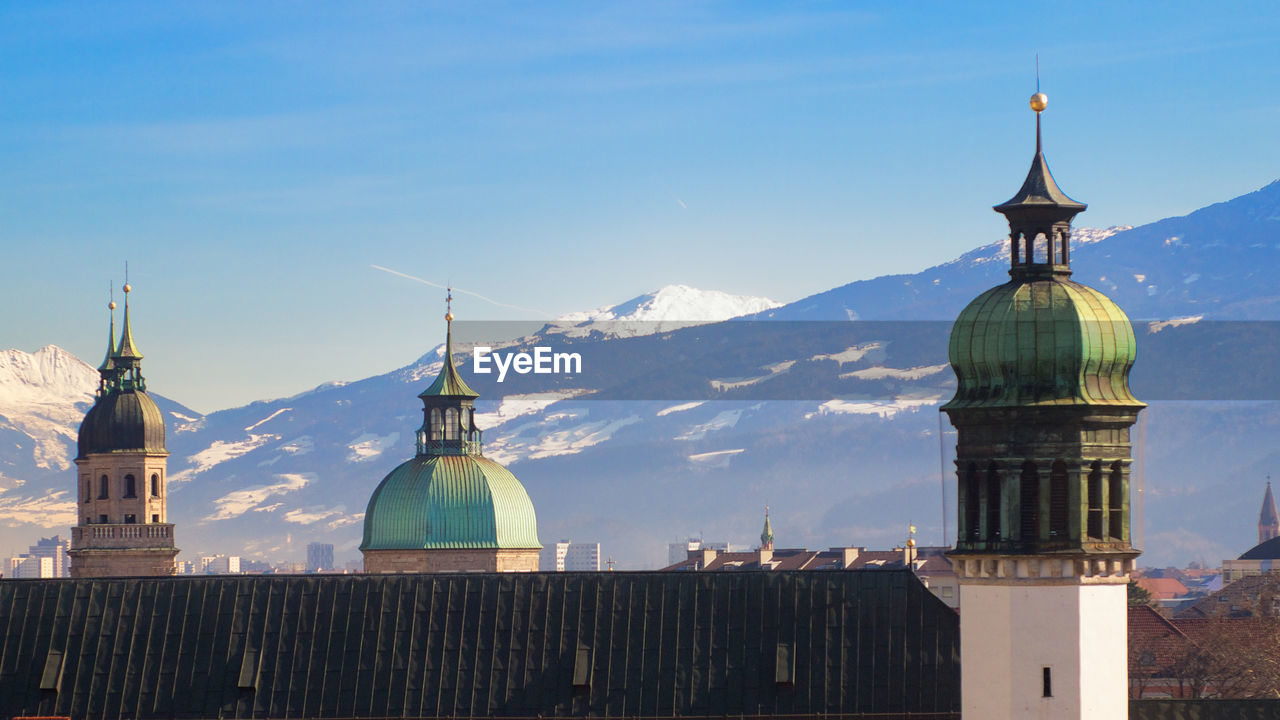 Historic church by snowcapped mountain against sky