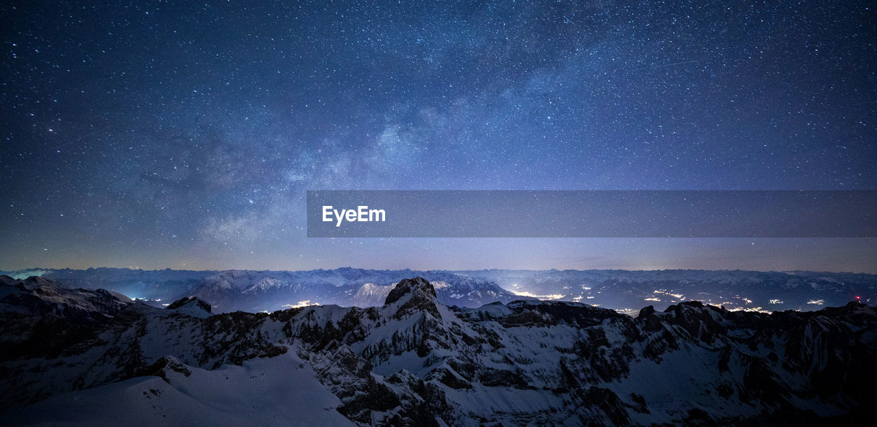 Scenic view of snowcapped mountains against sky at night