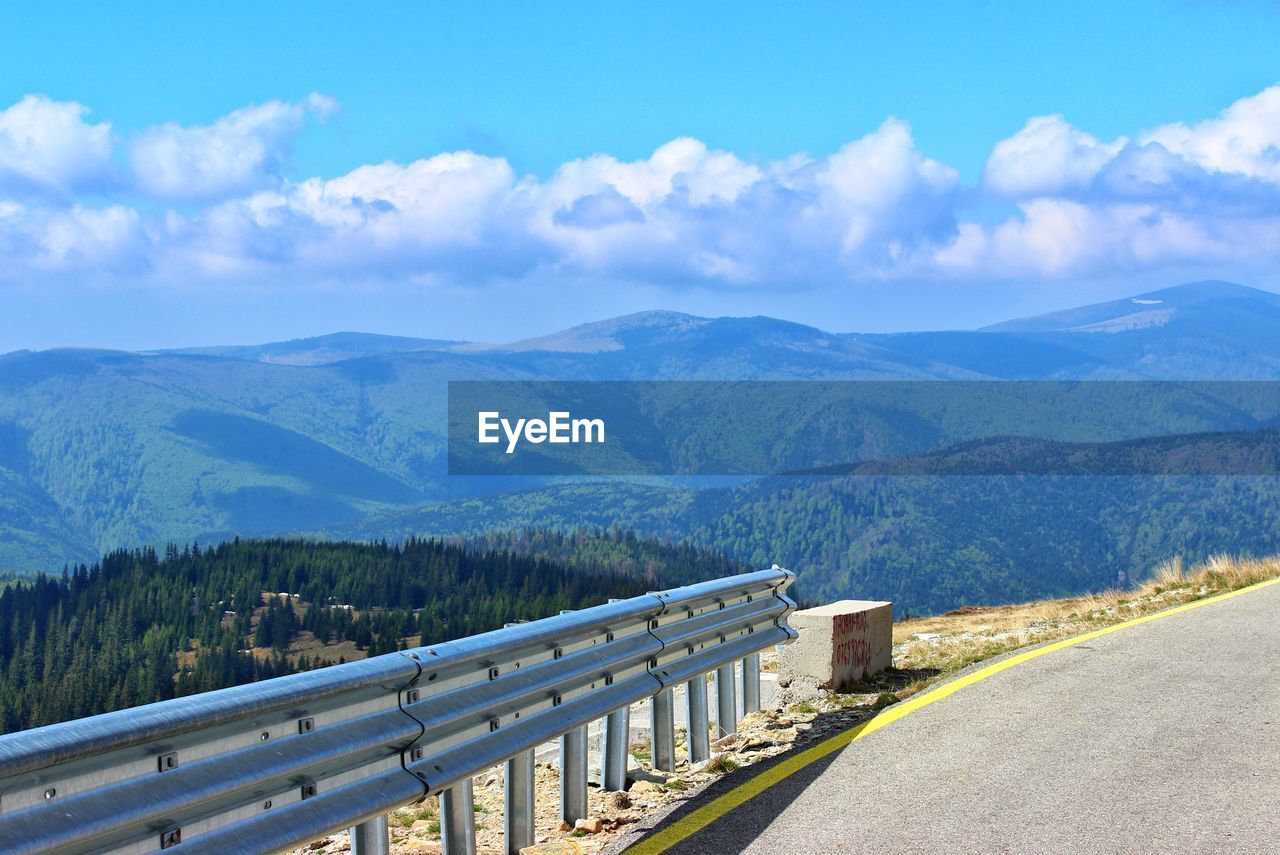 PANORAMIC VIEW OF ROAD BY MOUNTAINS AGAINST SKY