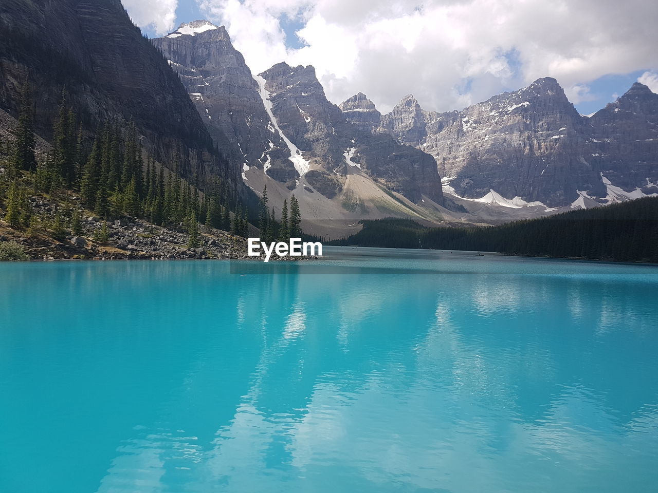 Scenic view of lake by mountains against sky