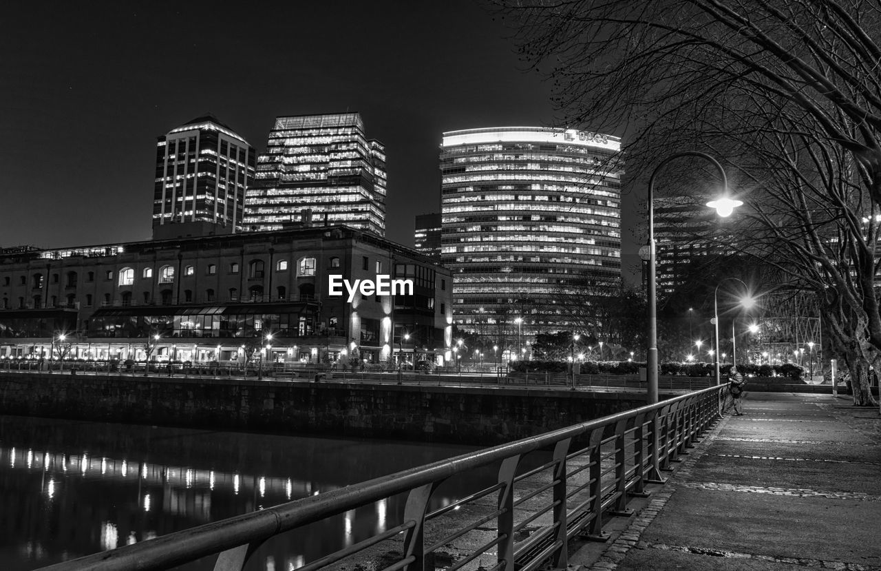 Illuminated cityscape against sky at night