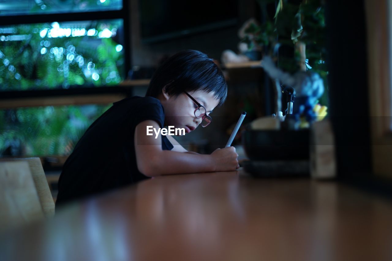 Girl writing at table in home