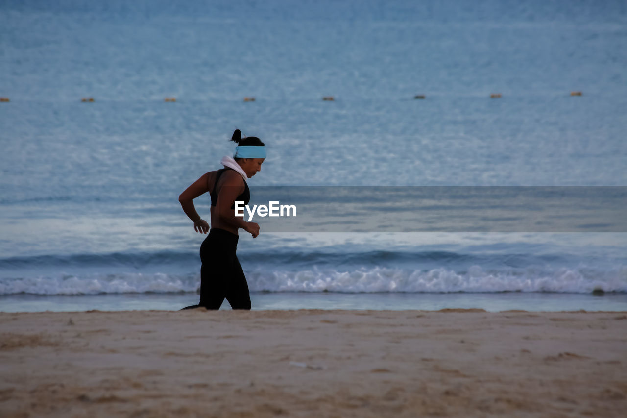 FULL LENGTH OF MAN STANDING AT BEACH