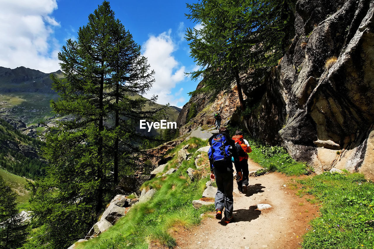 REAR VIEW OF WOMAN WALKING ON MOUNTAIN LANDSCAPE