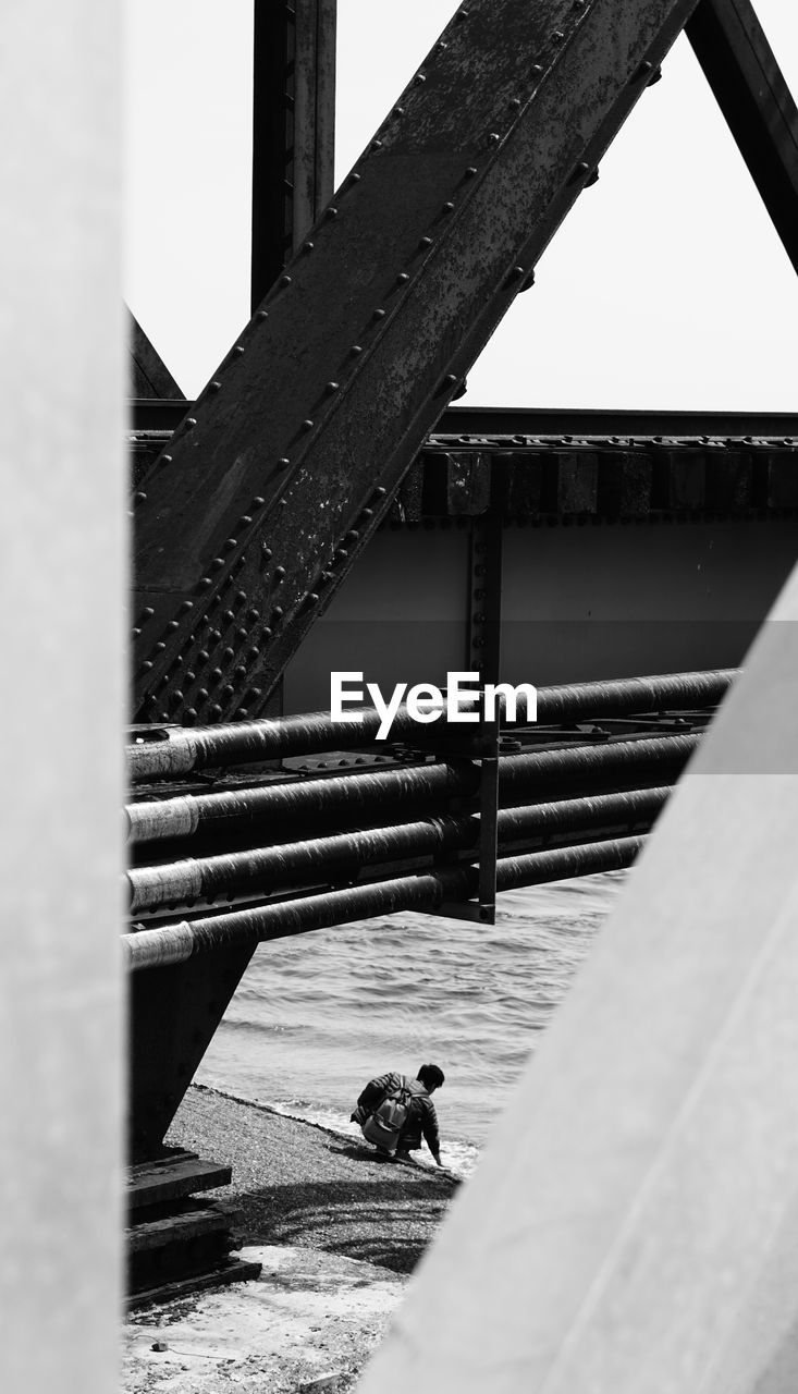 MAN ON BRIDGE AGAINST SKY