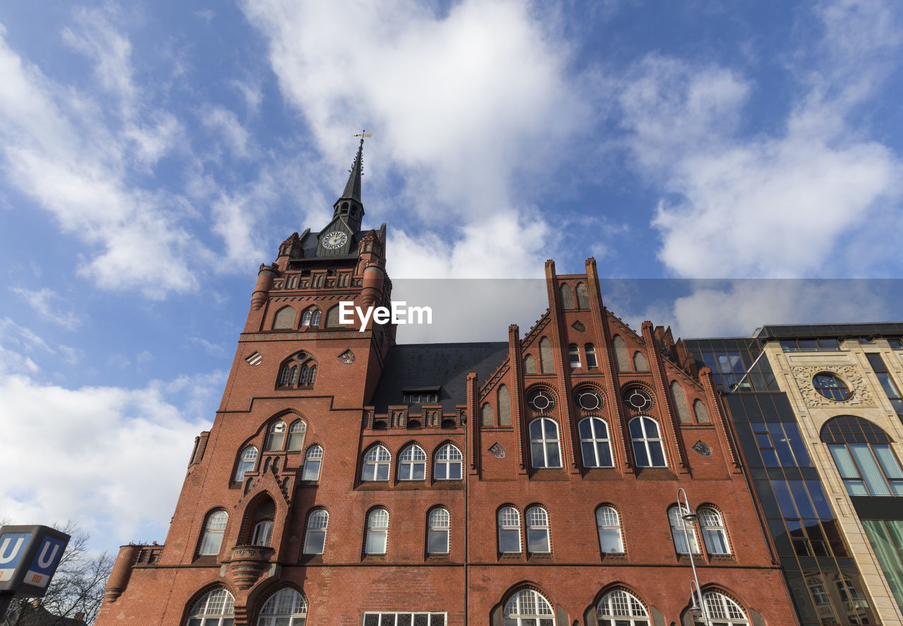 LOW ANGLE VIEW OF CLOCK TOWER AGAINST CLOUDY SKY