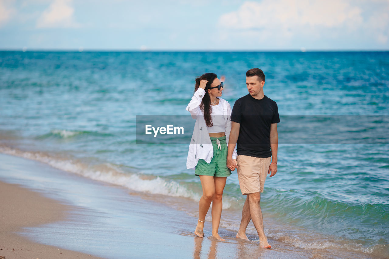 full length of young woman standing at beach