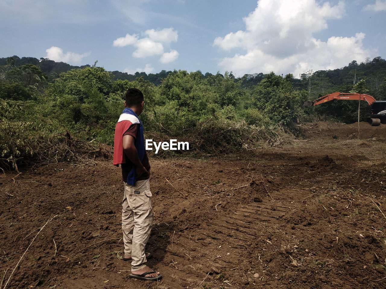 soil, field, one person, full length, nature, land, landscape, sky, agriculture, plant, cloud, environment, occupation, rural area, men, tree, rural scene, dirt, adult, natural environment, rear view, day, casual clothing, outdoors, person, lifestyles, working, farm, childhood, standing, growth