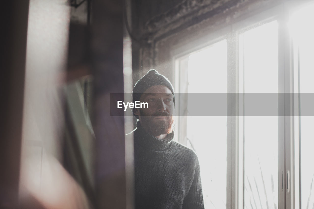 Man looking away by window