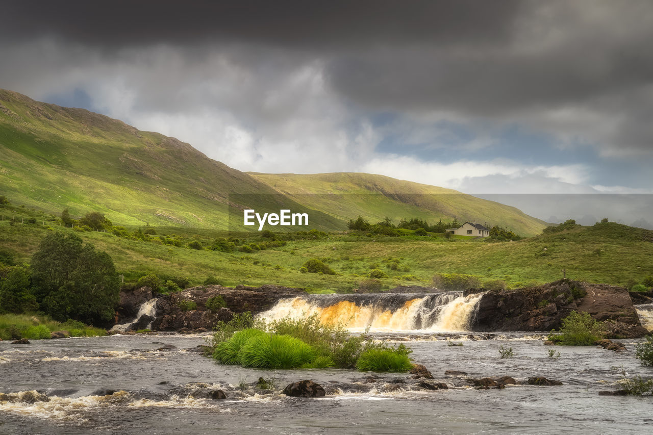 Aasleagh falls on erriff river with a single house under letterass mountains, ireland