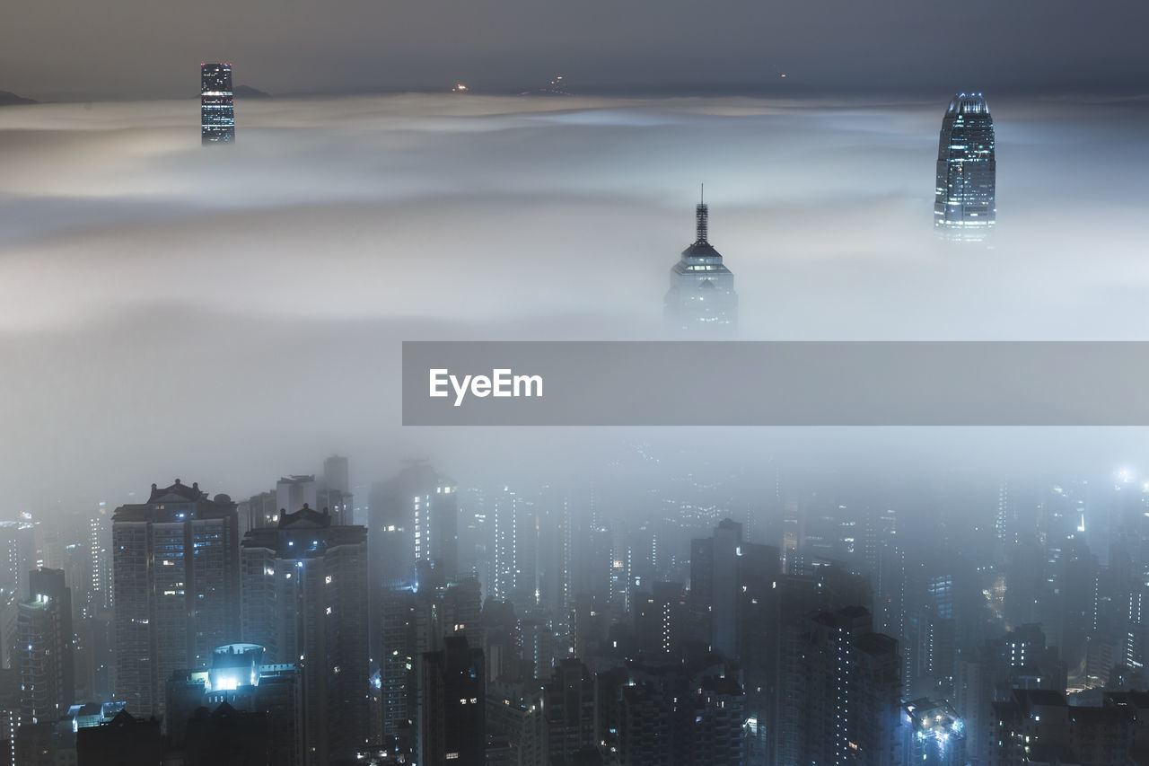 Modern buildings amidst fog at night