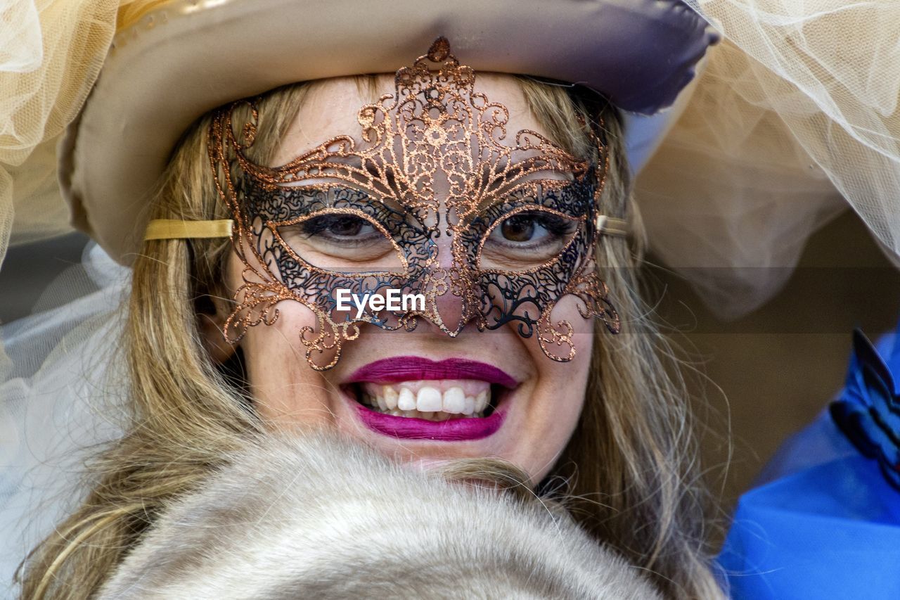 Close-up portrait of smiling woman in costume and mask during event