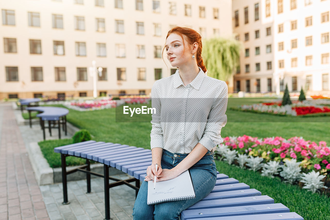 Woman holding book in campus