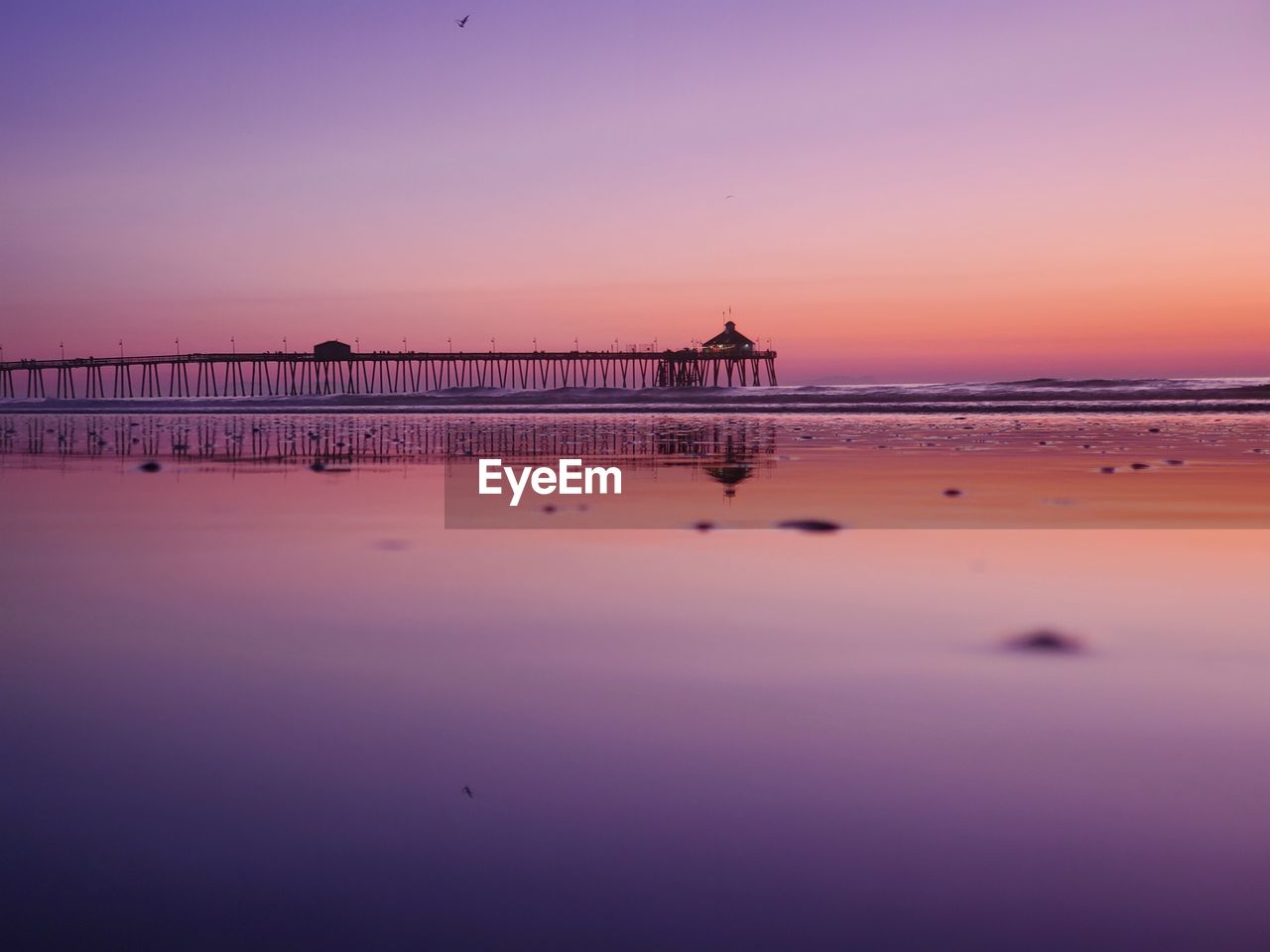 Pier over sea against sky during sunset