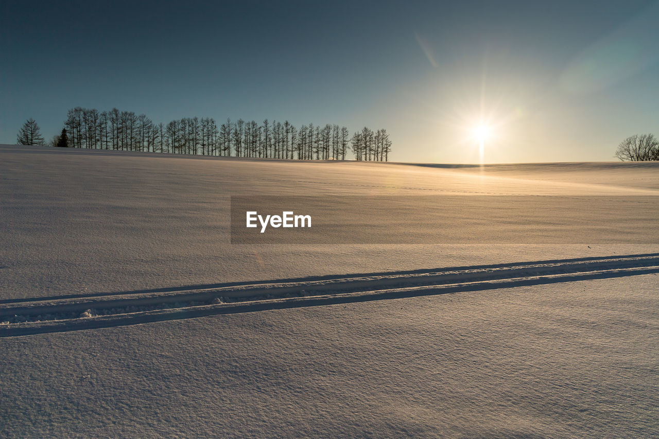 Scenic view of snow field against sky during sunset