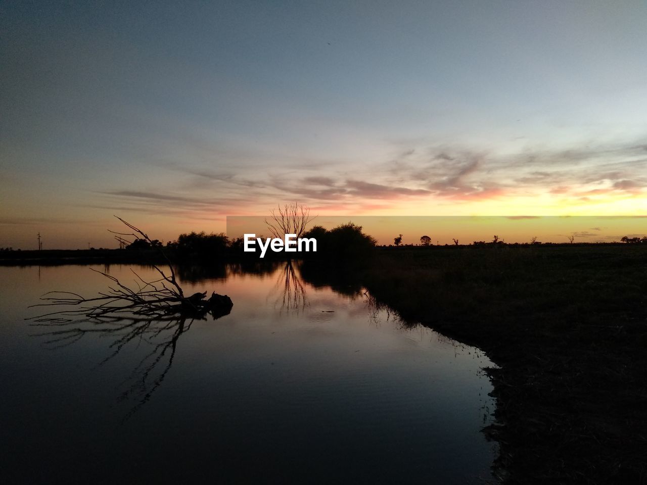 SILHOUETTE TREES BY LAKE AGAINST SKY DURING SUNSET