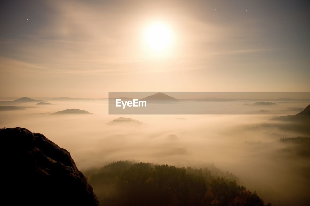 Full moon night with sunrise in a beautiful mountain park.  sandstone peaks and hills in night