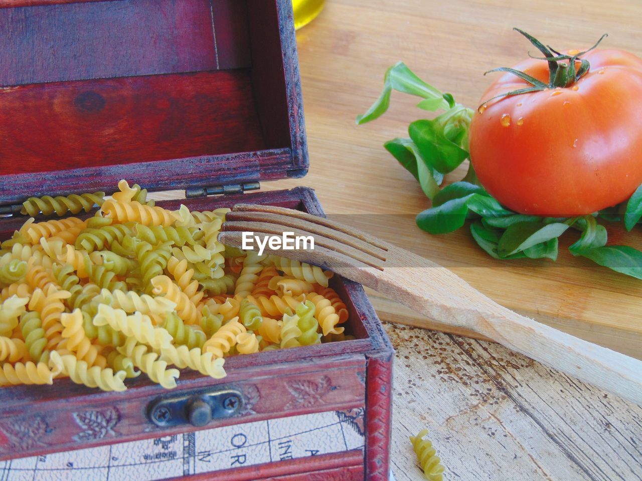 High angle view of pasta in container with vegetables on table