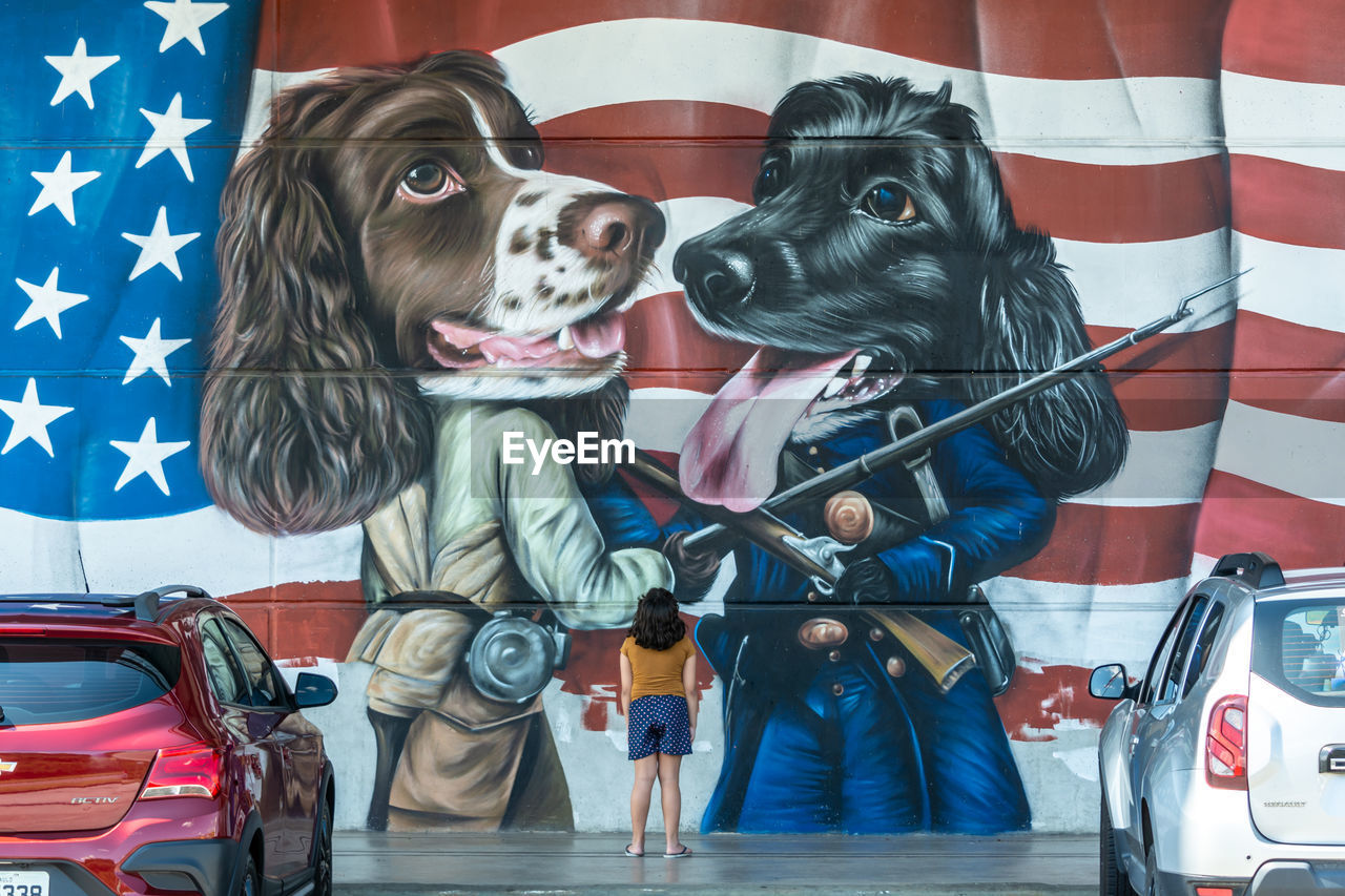 PORTRAIT OF DOG STANDING BY CAR ON FLOOR