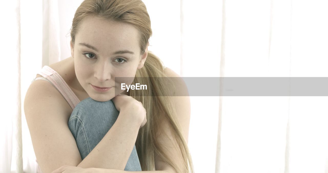 PORTRAIT OF A BEAUTIFUL YOUNG WOMAN SITTING