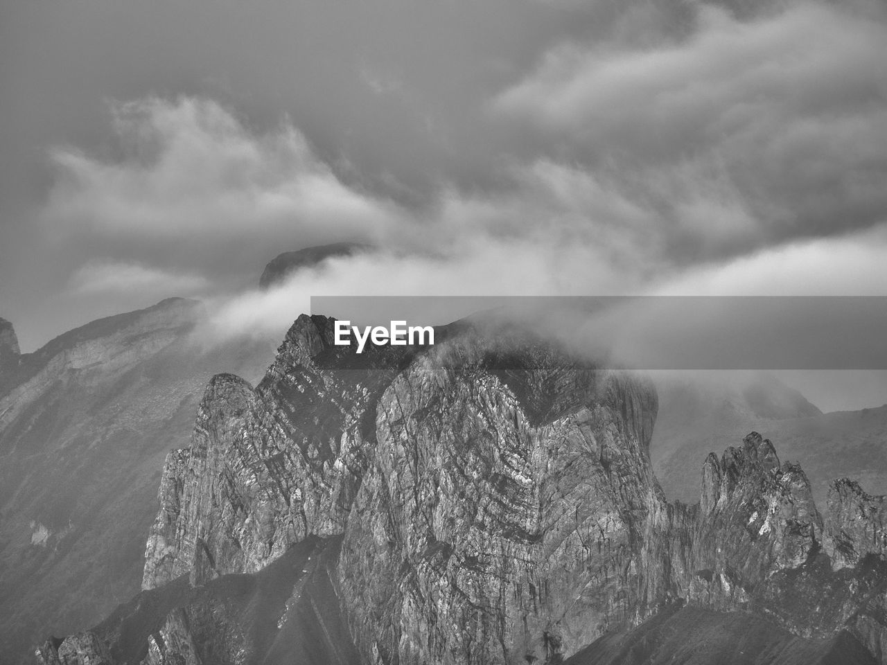 mountain, environment, nature, cloud, black and white, landscape, scenics - nature, sky, monochrome, beauty in nature, mountain range, monochrome photography, fog, snow, land, mountain peak, travel destinations, travel, no people, outdoors, tree, forest, tourism, panoramic, rock, non-urban scene, plant, cold temperature, mist, tranquility, pinaceae, high up, winter, darkness, tranquil scene