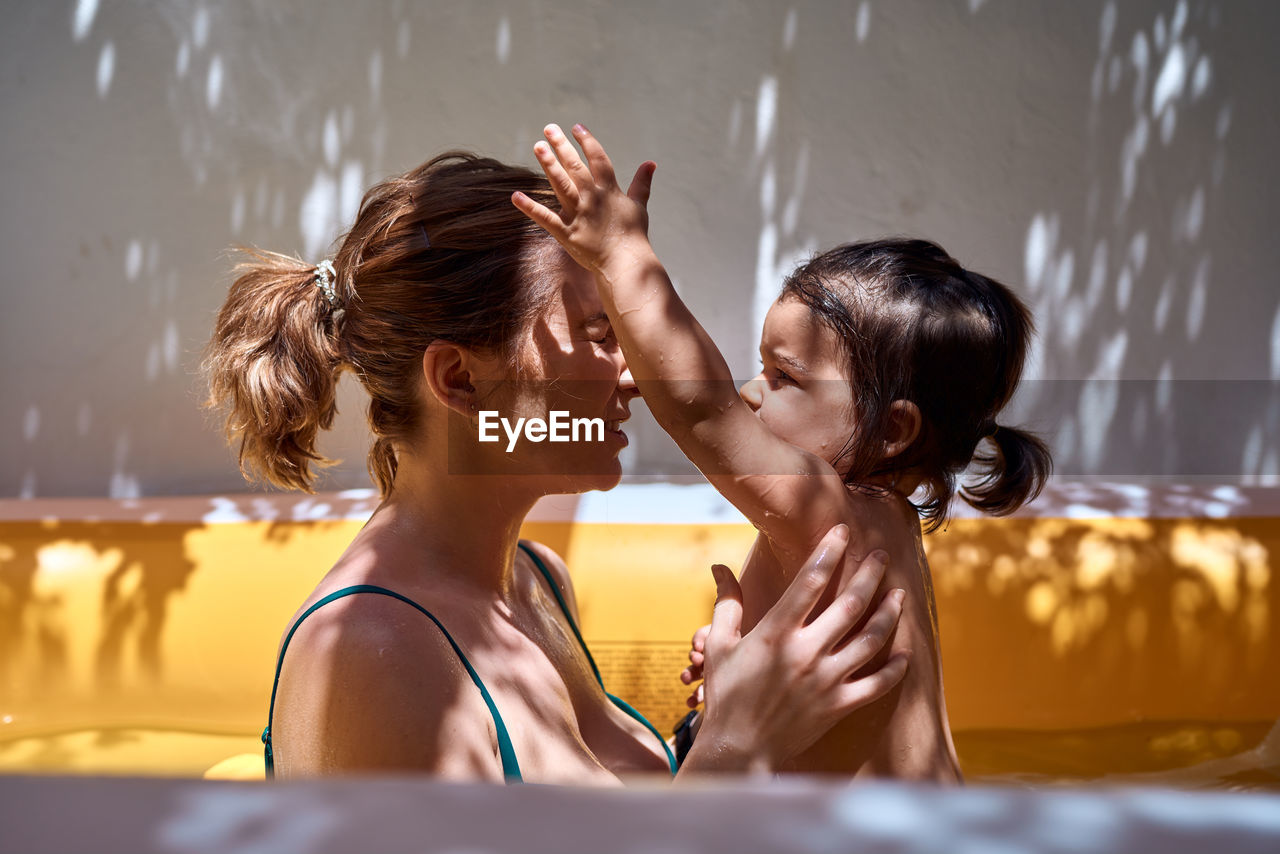 Young mother in an inflatable pool with her little daughter. concept holidays