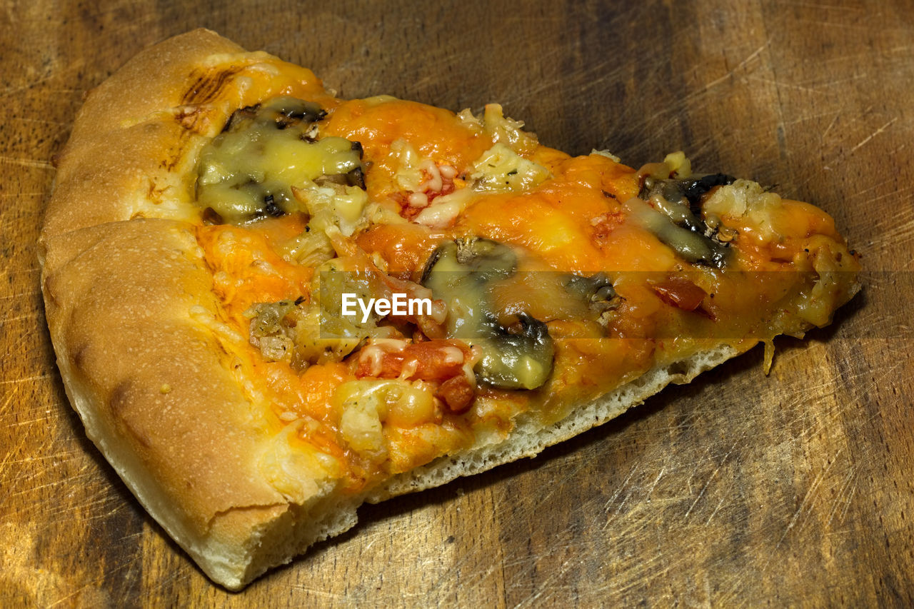 High angle view of pizza slice on cutting board