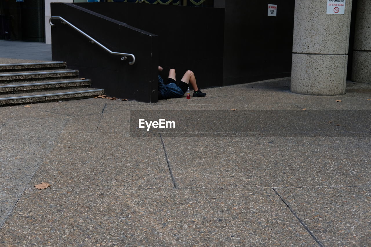 LOW SECTION OF WOMAN SITTING IN STEPS