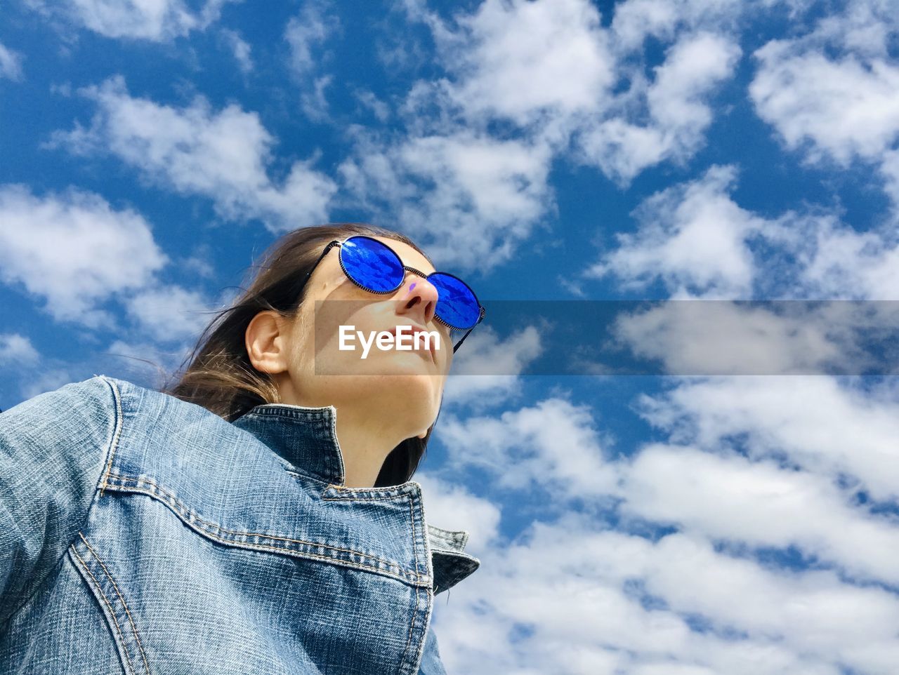 Low angle view of woman looking away against sky