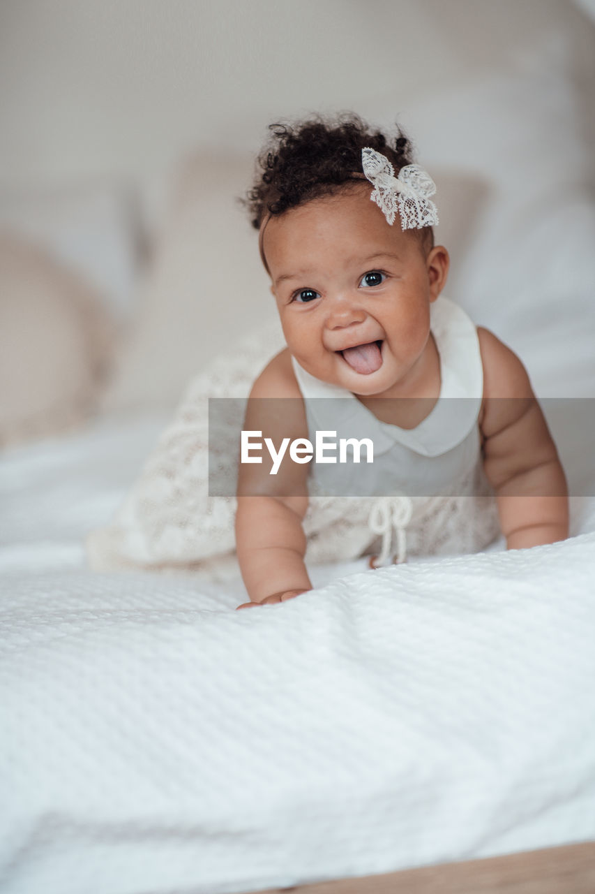 Portrait of cute baby girl on bed