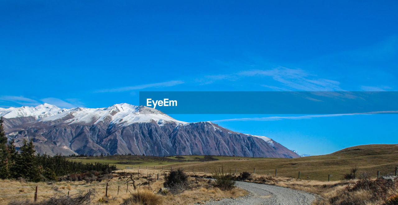 Scenic view of snowcapped mountains against blue sky