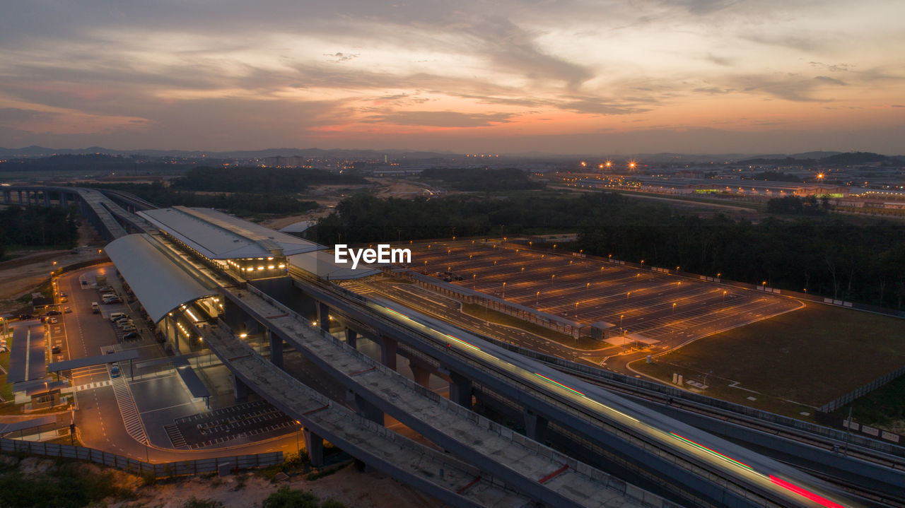 High angle view of illuminated cityscape against sky during sunset