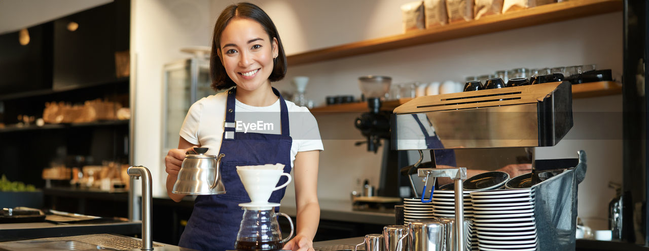 portrait of young woman standing in kitchen