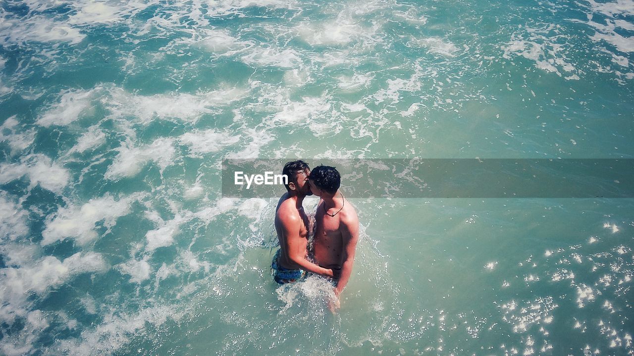 HIGH ANGLE VIEW OF FRIENDS AT SEA SHORE